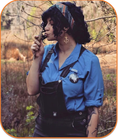 Lameace Hussain, PhD Candidate, holding a frog while working in the field